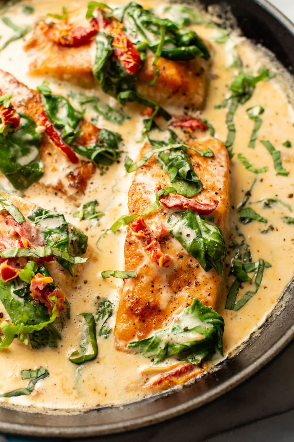 a skillet with creamy tuscan salmon