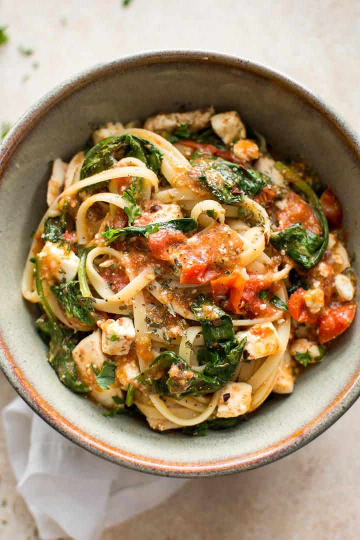 healthy chicken feta spinach pasta in stoneware bowl