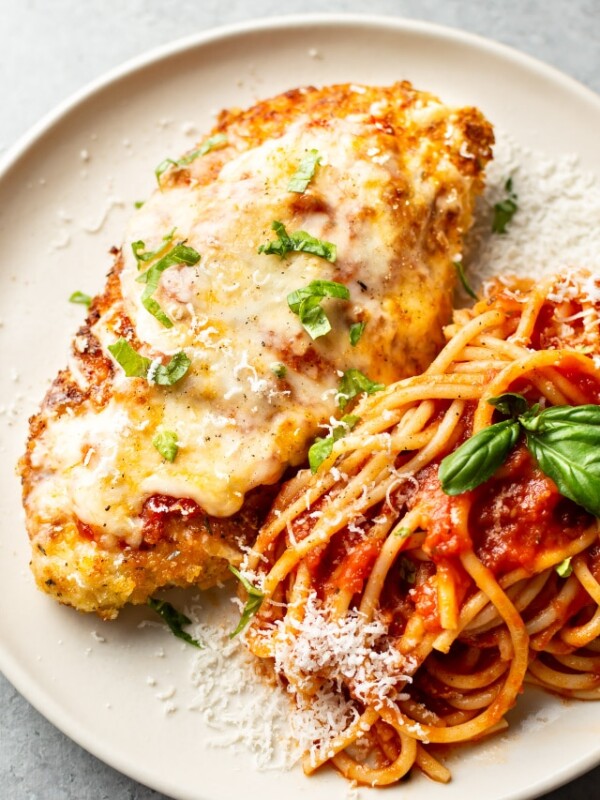 chicken parmesan on a plate with spaghetti and marinara sauce