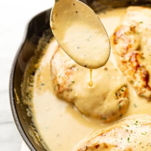 a skillet with lemon pepper chicken and a serving spoon