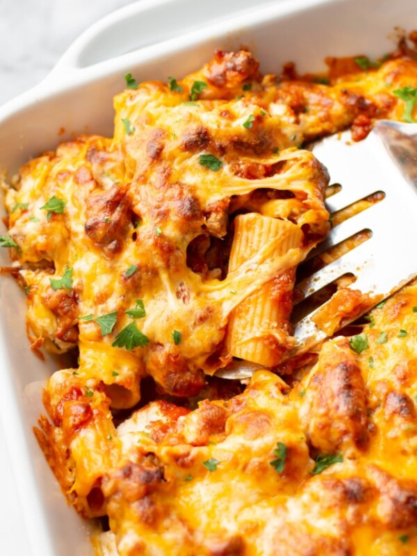 close-up of baking dish with baked rigatoni and spatula