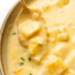 closeup of a bowl of cheesy potato soup with a spoon