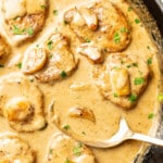 a skillet with creamy garlic pork tenderloin and a serving spoon