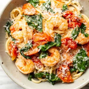 a bowl of tomato spinach shrimp pasta