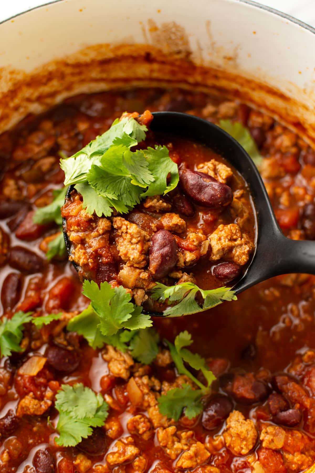 a pot of turkey chili with a ladle