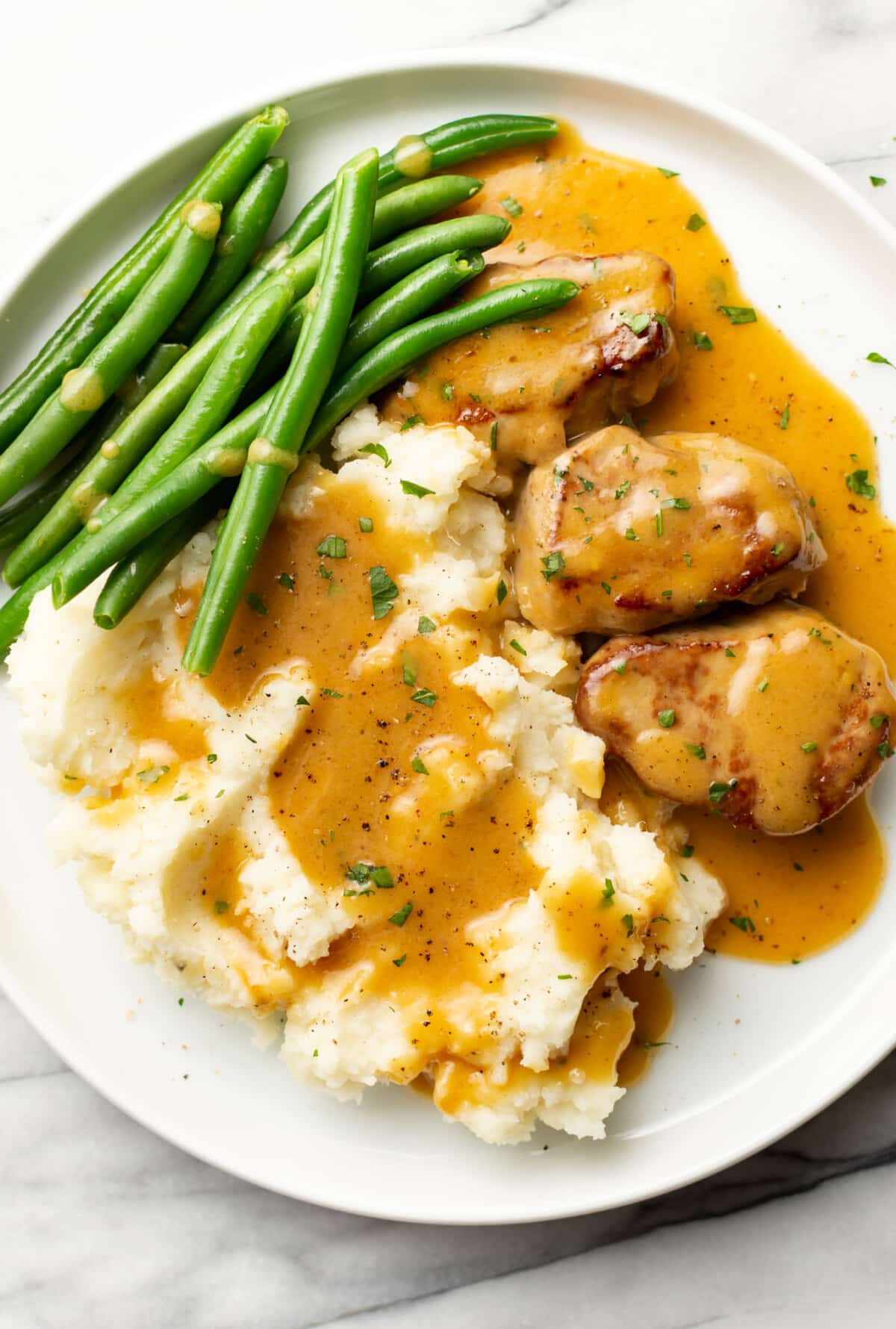 a plate with honey mustard pork tenderloin, green beans, and mashed potatoes