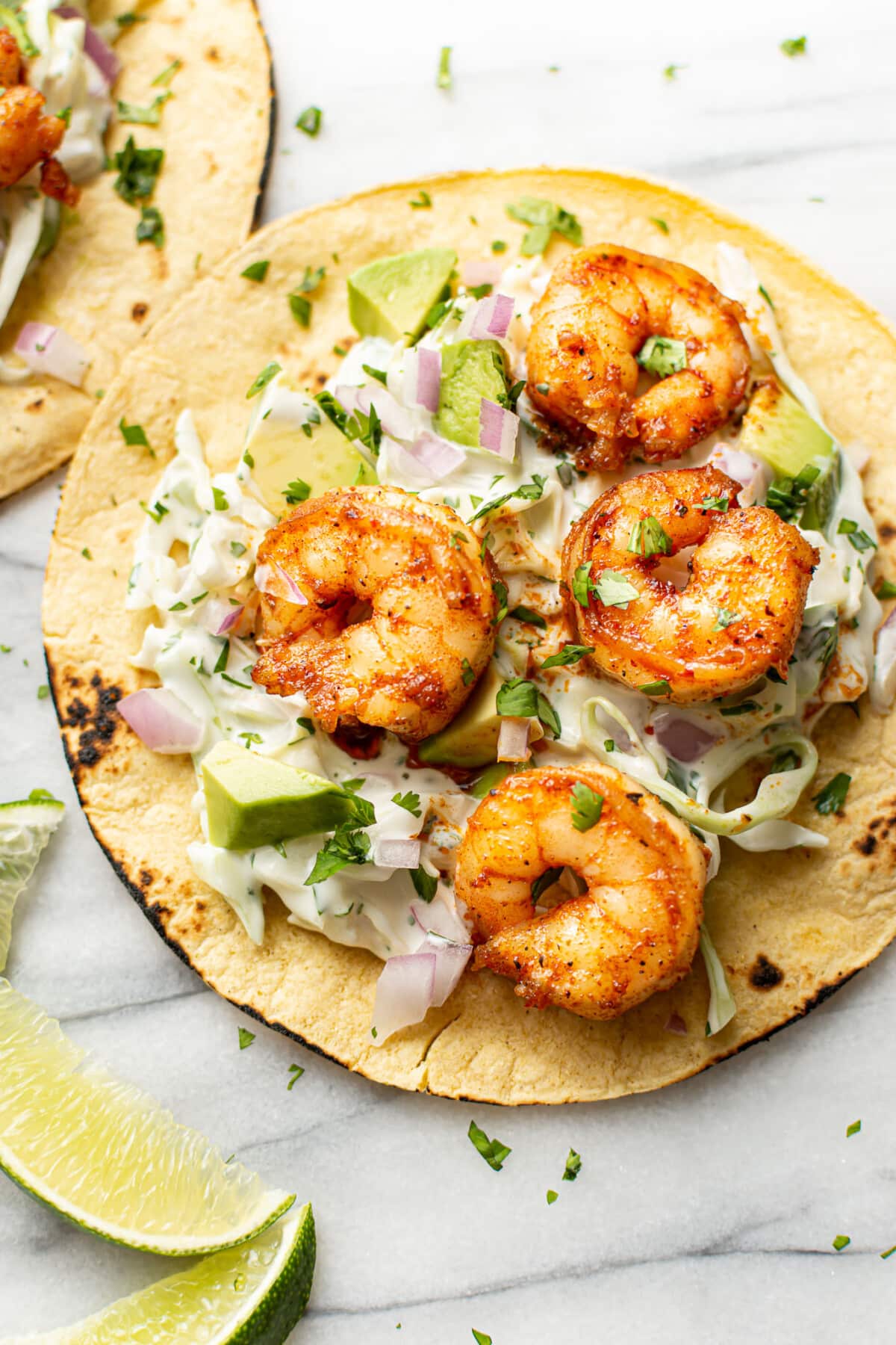 two shrimp tacos with lime wedges