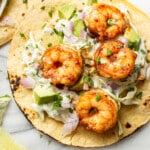 two shrimp tacos with lime wedges