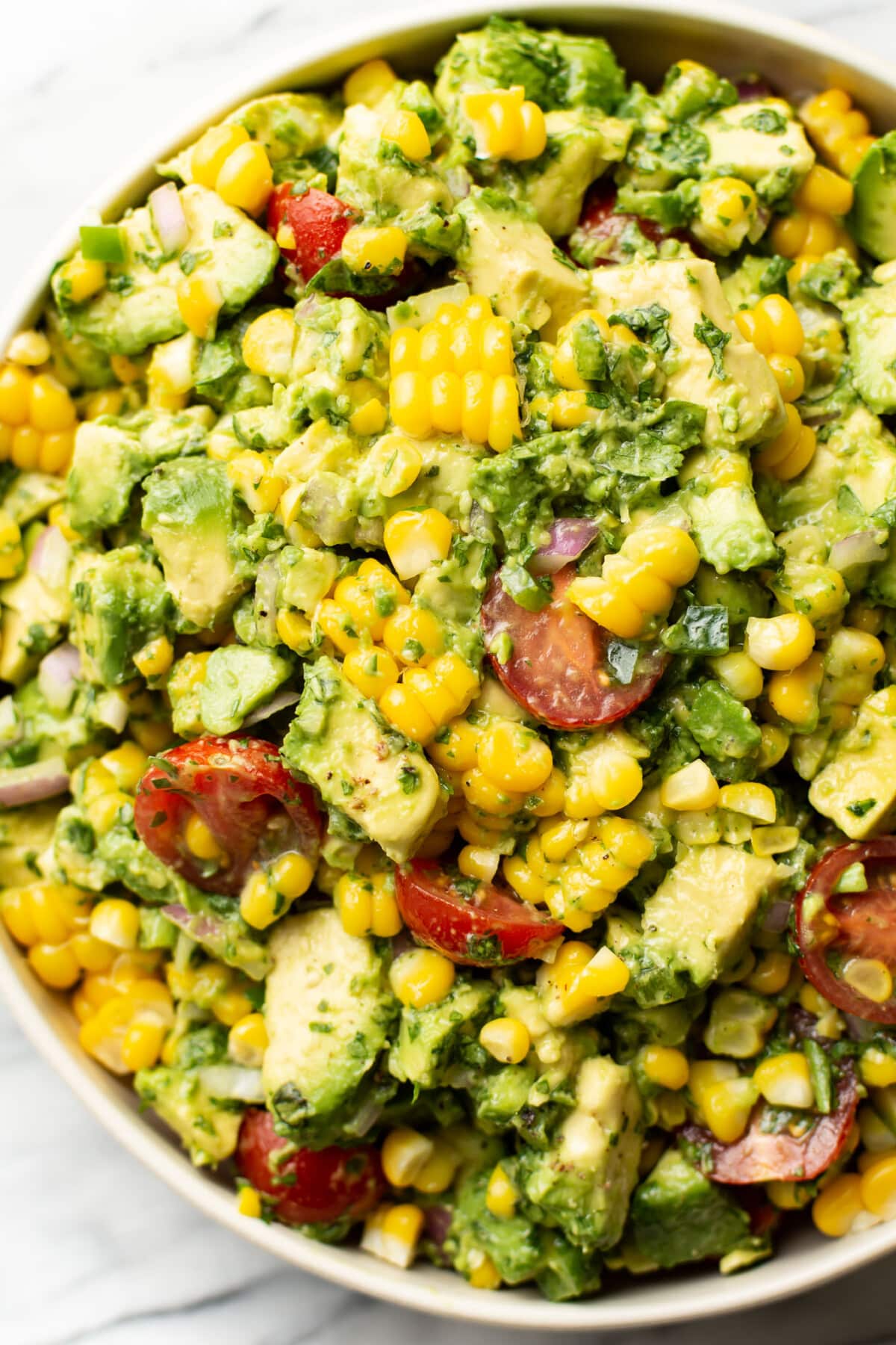 a large bowl of avocado corn salad