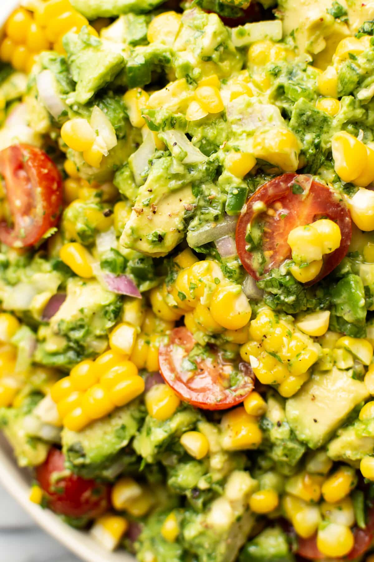 closeup of a bowl of corn salad with avocado