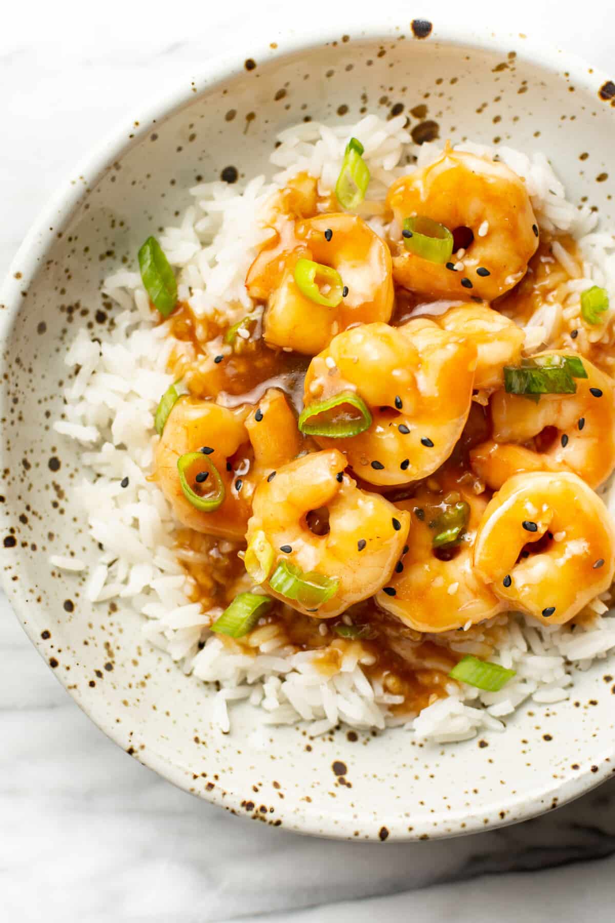 a bowl of honey garlic shrimp over rice