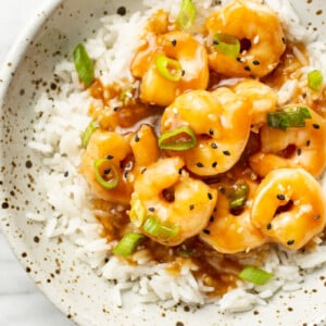 a bowl of honey garlic shrimp over rice