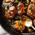 a skillet with teriyaki pork tenderloin and a serving spoon