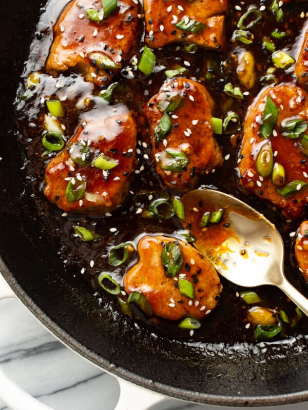 a skillet with teriyaki pork tenderloin and a serving spoon