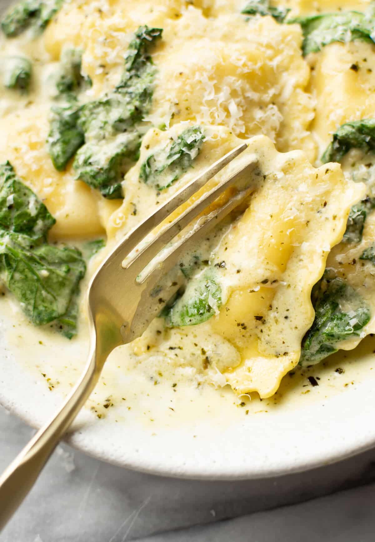 a dish with creamy pesto ravioli and a fork