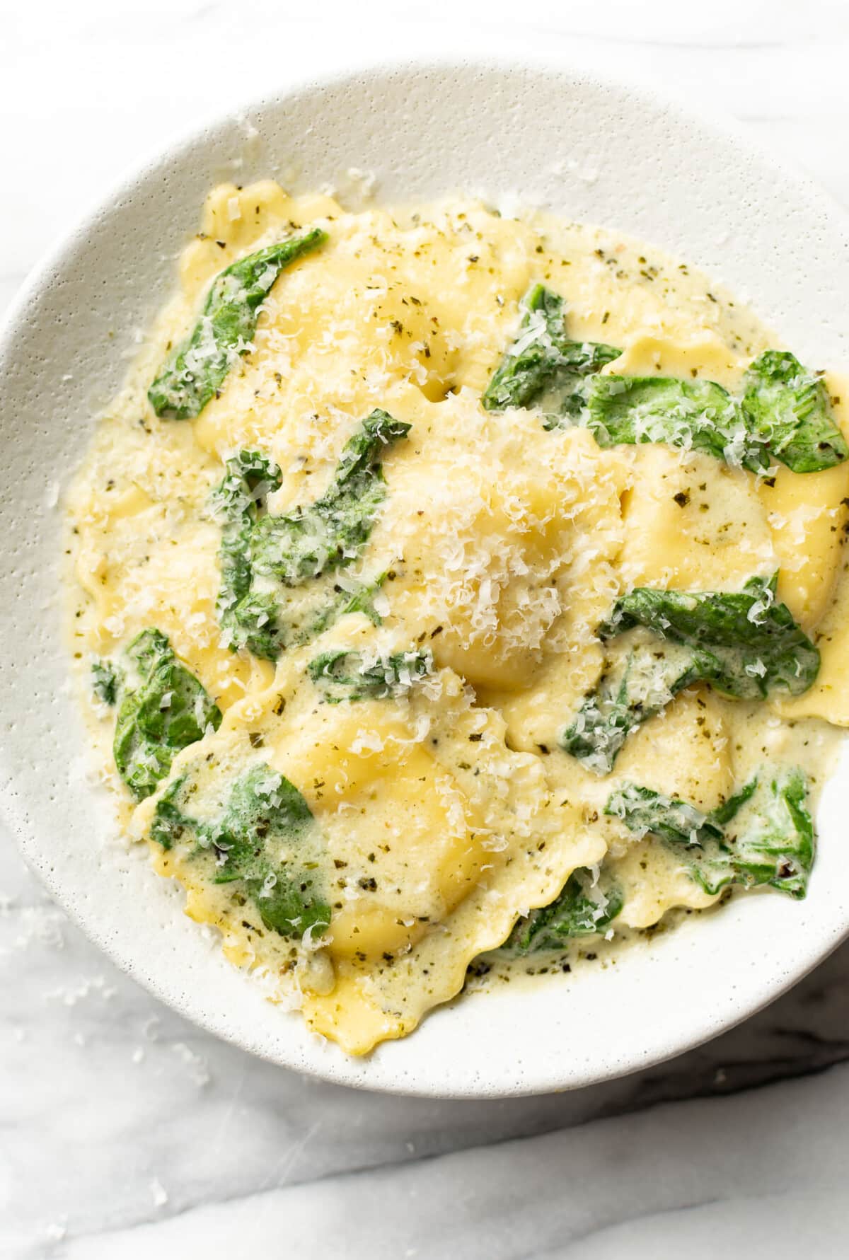 a bowl of creamy pesto ravioli