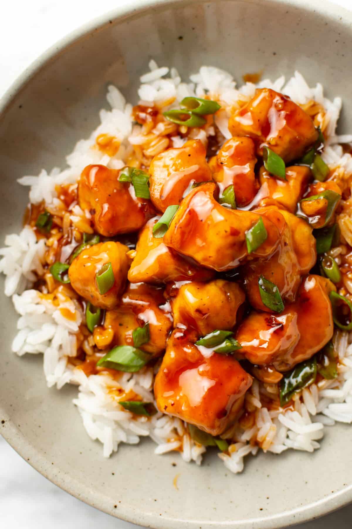 a bowl of firecracker chicken over rice