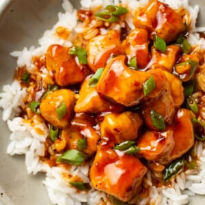 a bowl of firecracker chicken over rice