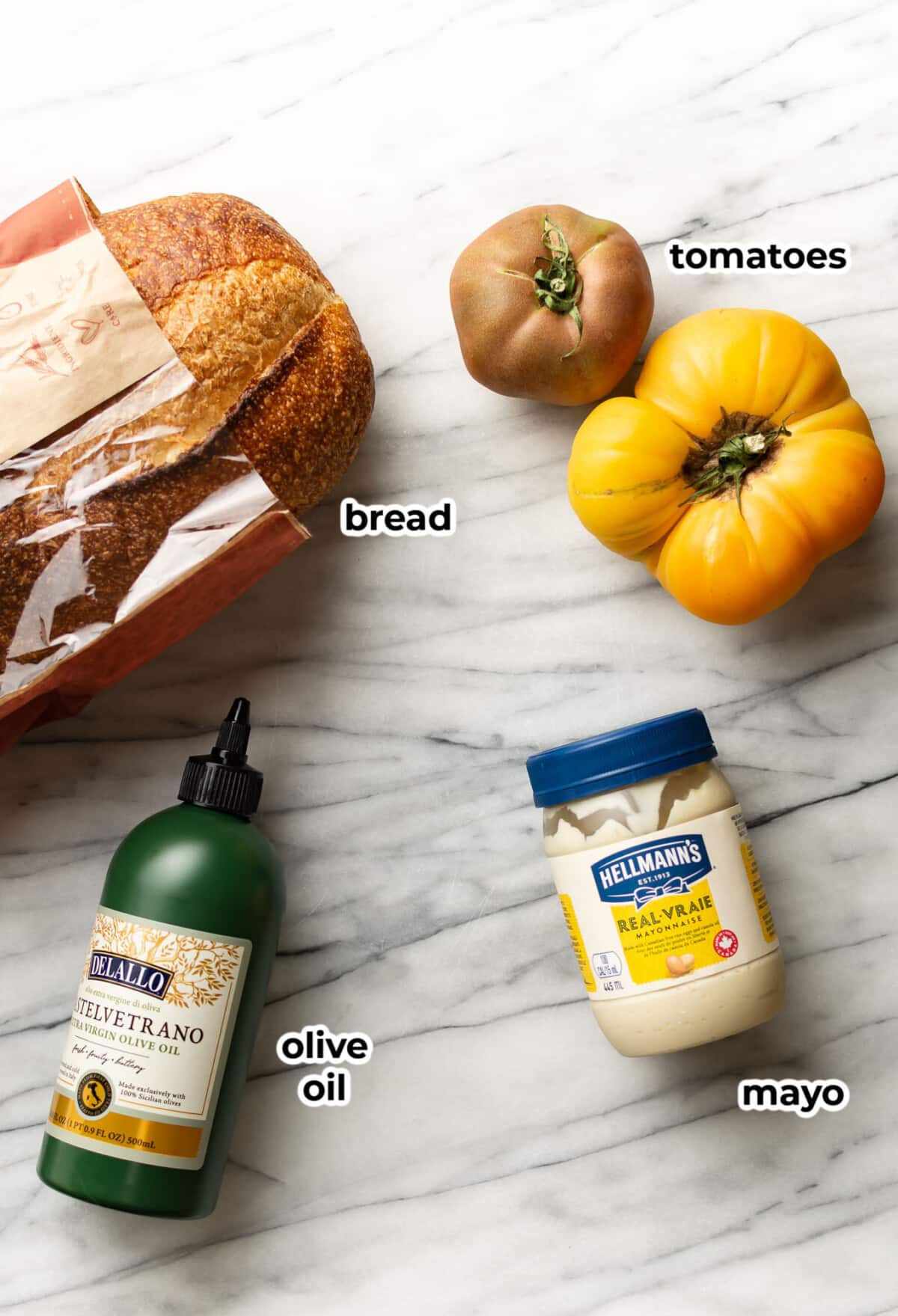 ingredients for tomato sandwiches on a marble counter