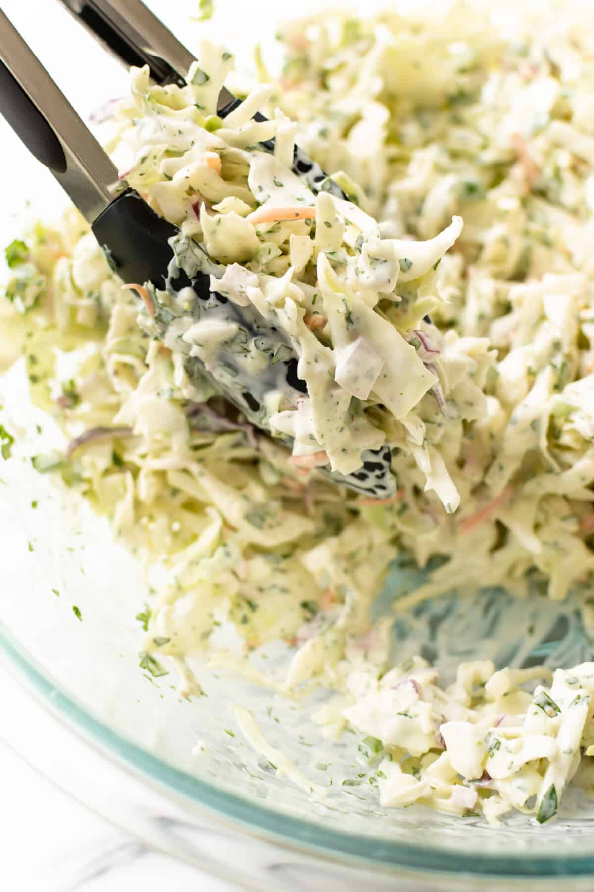 closeup of a bowl of jalapeno slaw with servings tongs