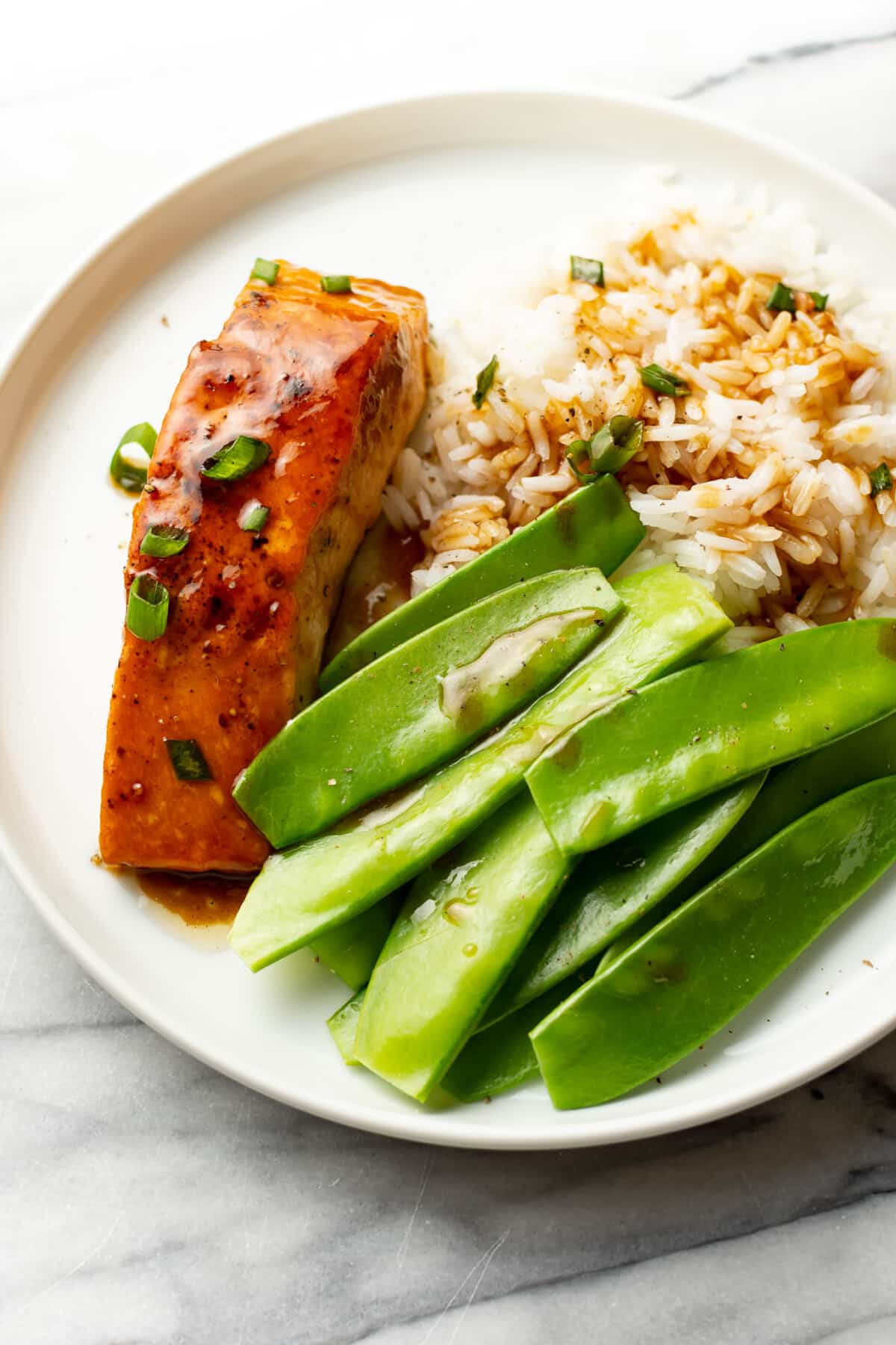 a plate with maple glazed salmon, snow peas, and rice