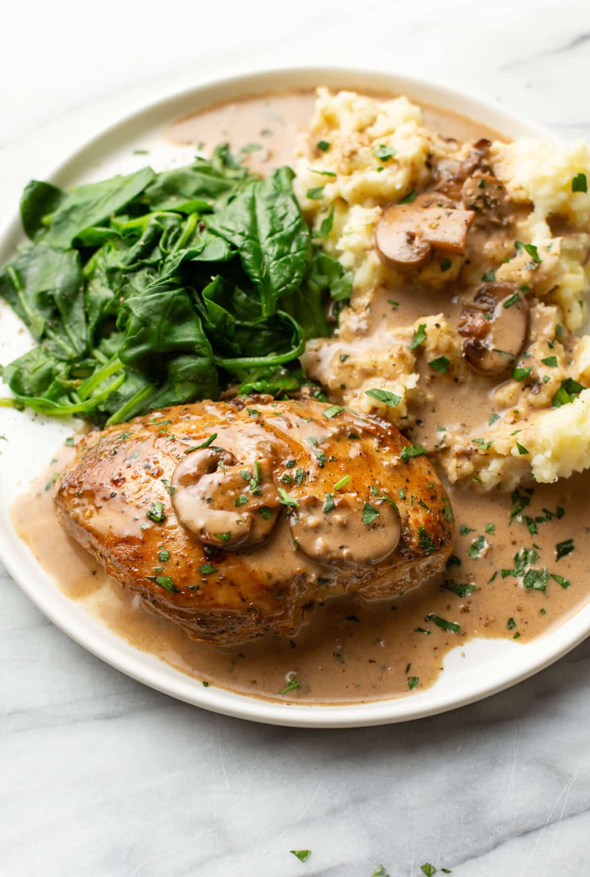 a plate with balsamic chicken, mashed potatoes, and spinach