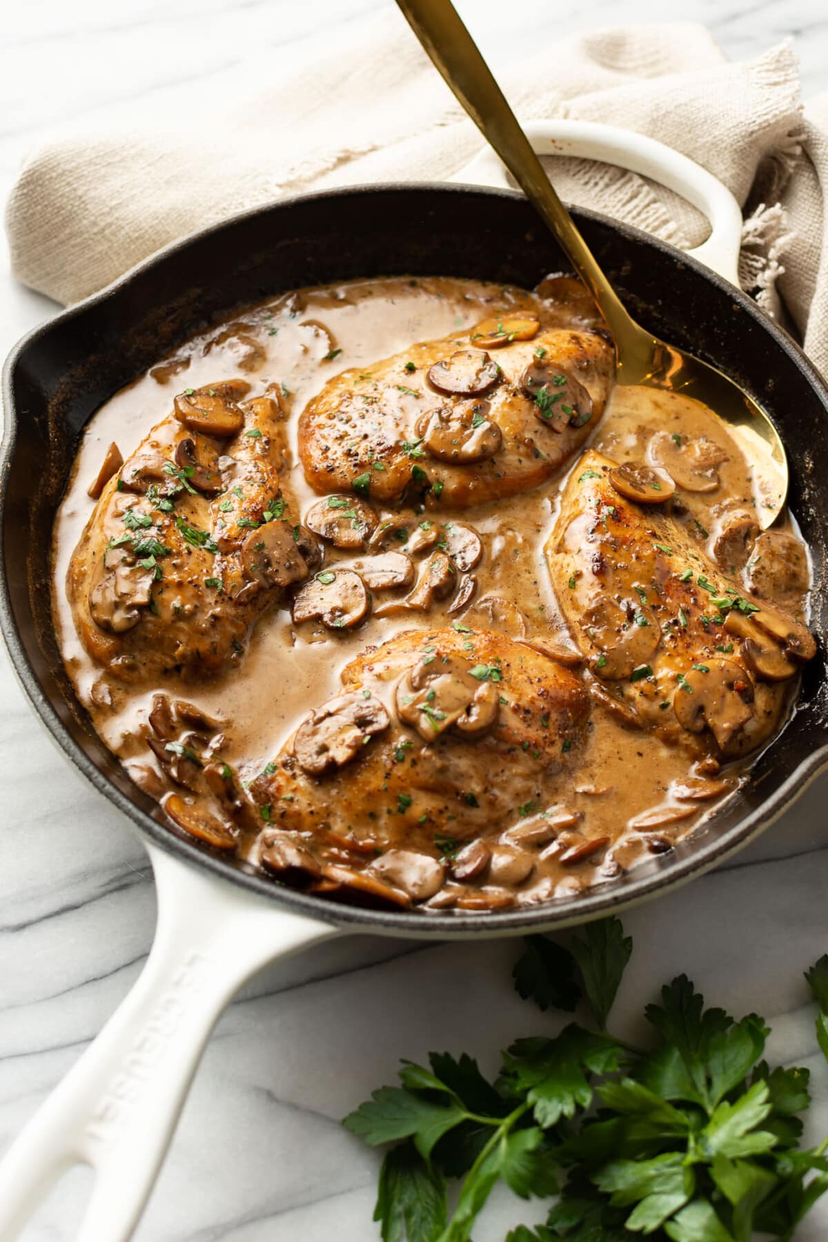 a skillet with balsamic chicken and a serving spoon