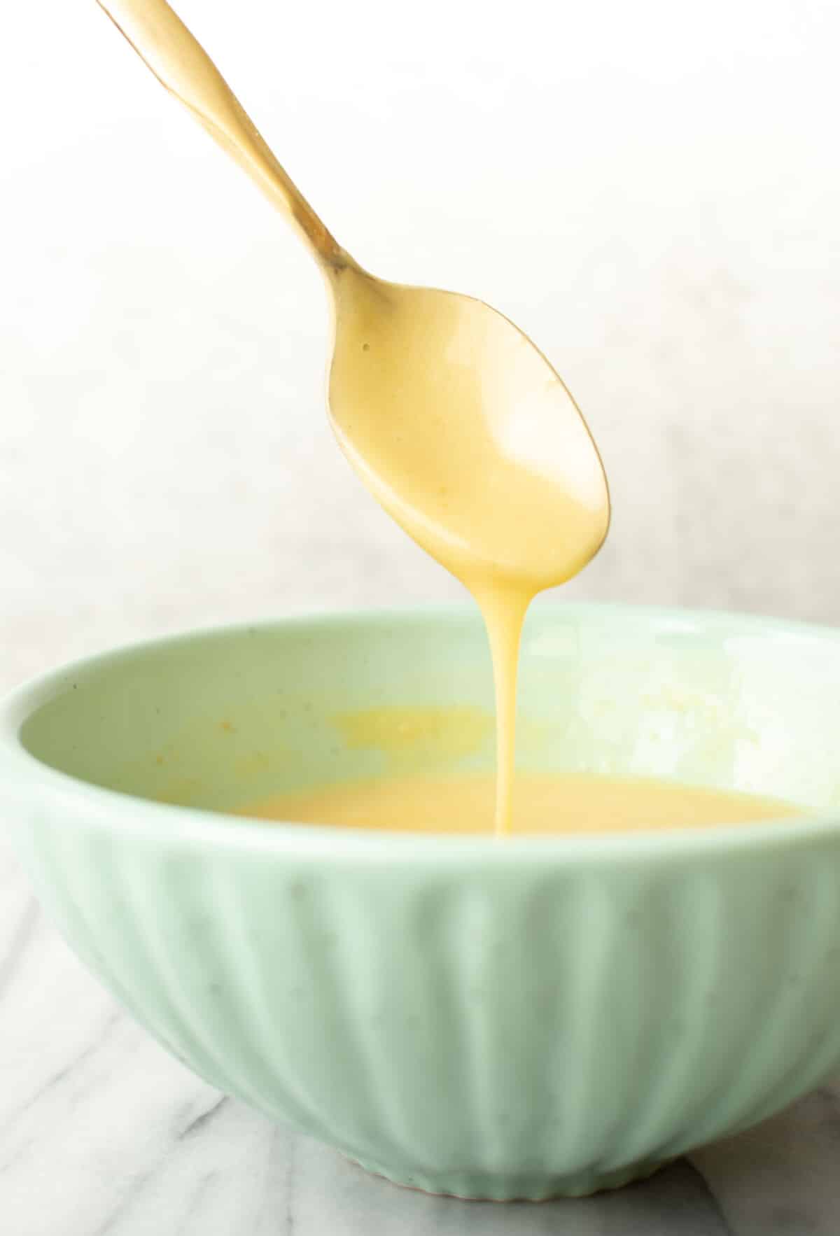 a bowl of homemade honey mustard dipping sauce with a spoon