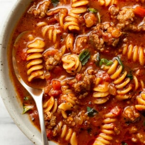 a bowl of italian sausage soup with a spoon