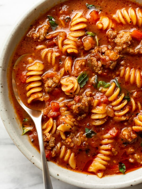 a bowl of italian sausage soup with a spoon