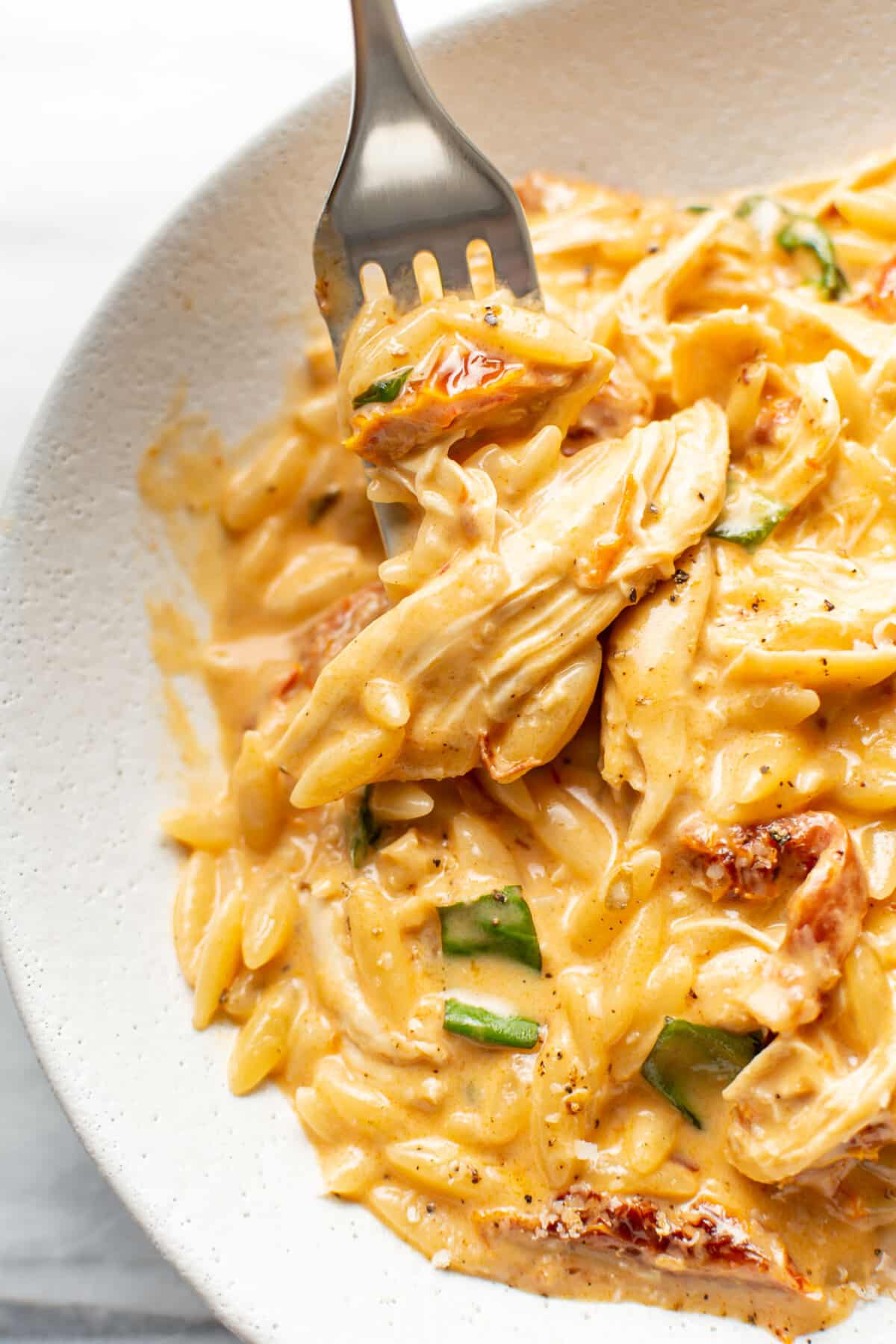 a bowl of marry me chicken orzo with a fork