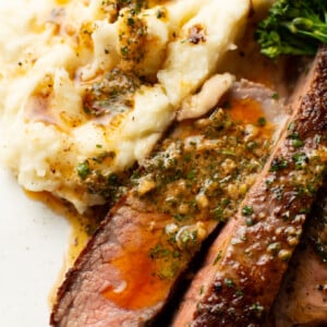 a plate with ribeye steak and cowboy butter along with mashed potatoes