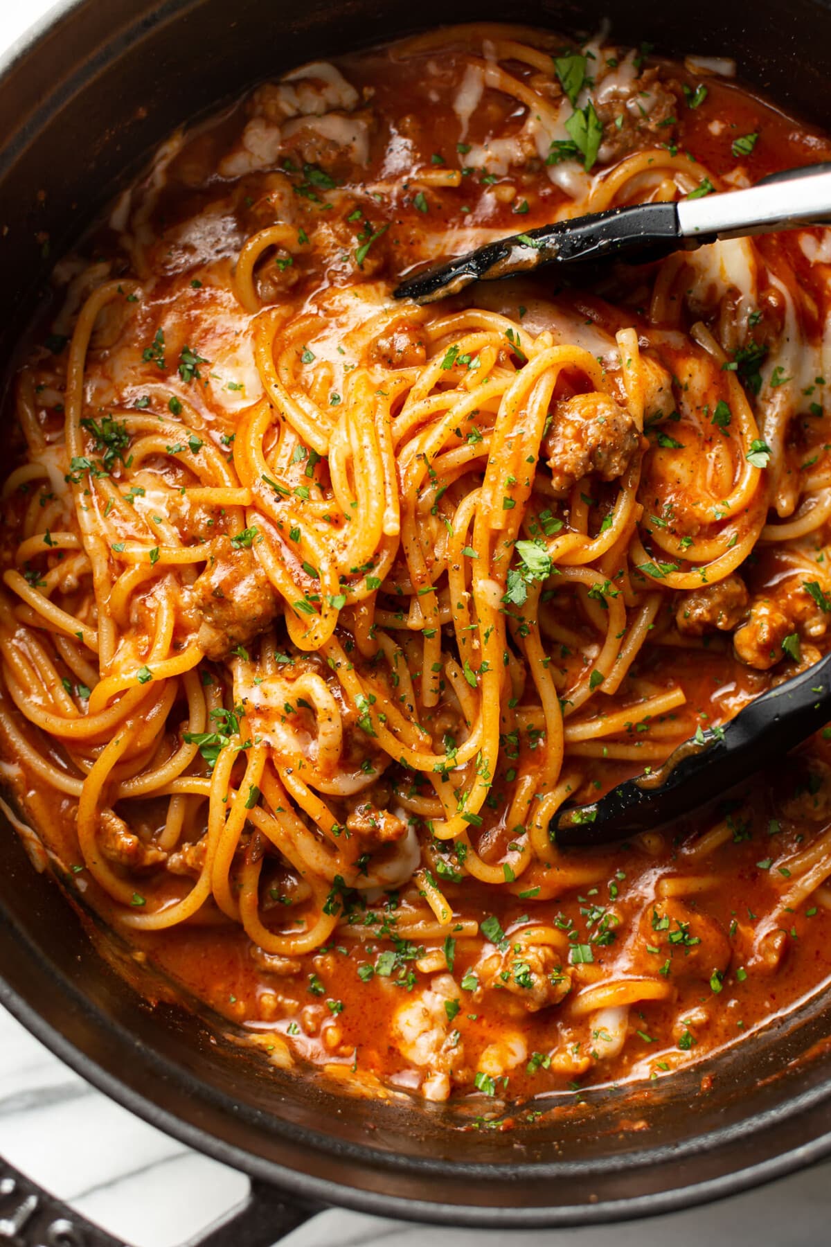 one pot italian sausage pasta with serving tongs