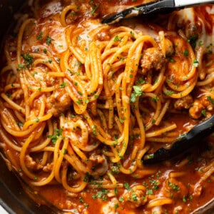 one pot italian sausage pasta with serving tongs