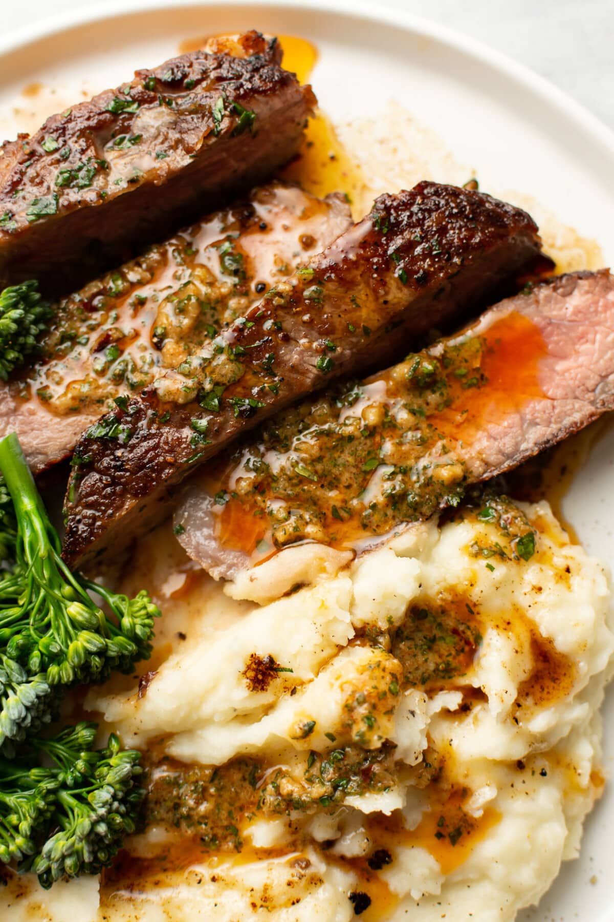 a plate with perfect ribeye steak, broccolini, mashed potatoes, and cowboy butter