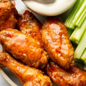 a plate of air fryer buffalo chicken wings with ranch dip and celery sticks