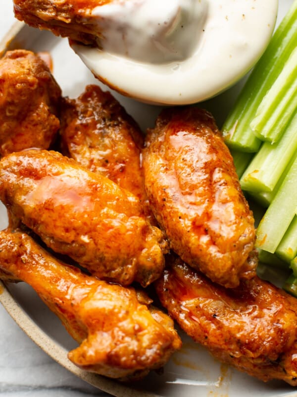 a plate of air fryer buffalo chicken wings with ranch dip and celery sticks