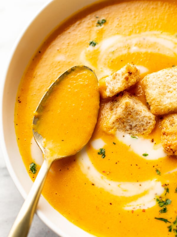 a bowl of carrot ginger soup with a spoon