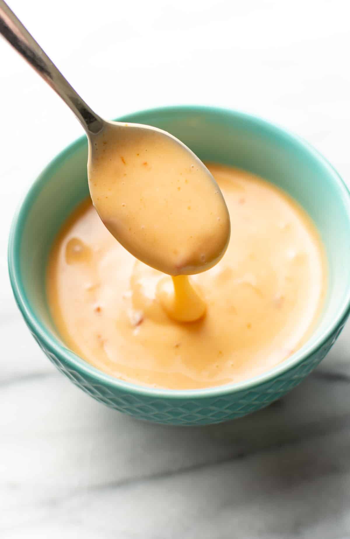 a bowl of bang bang sauce with a spoon