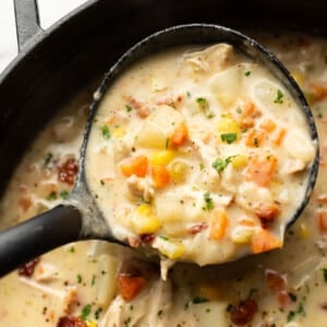 a ladle with creamy chicken and potato soup