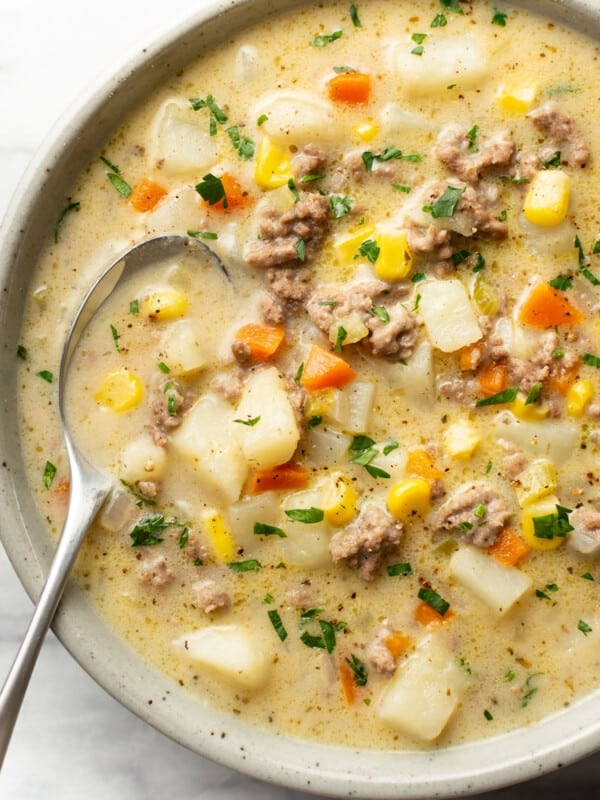 a bowl of creamy hamburger and potato soup with a spoon